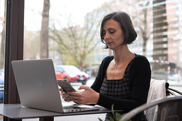 istock Woman working on laptop and phone in cafe 2248850710