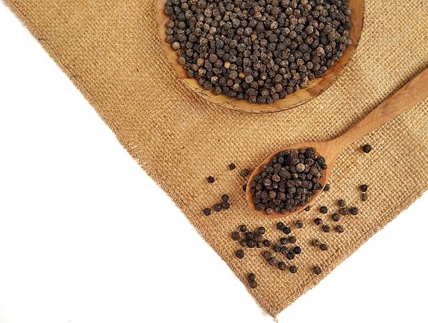 istock Dry black pepper on wooden spoon isolated on white background 2248851206