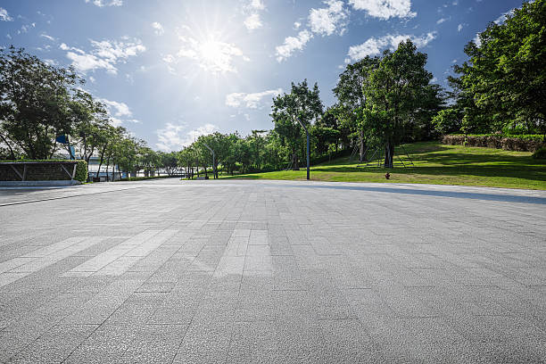 istock Empty square floor with green trees and blue sky sun background in the park. 2248852117