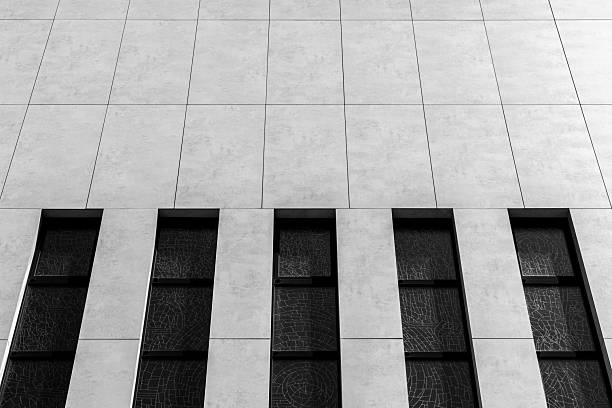 Front View Of A Modern Facade Featuring Tall Vertical Window Stripes With Stained Glass Pattern In Black And White, Emphasizing Repetition, Geometry And Contemporary Architecture Design For religious buildings