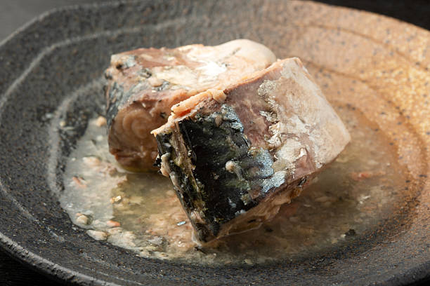 A can of boiled mackerel opened onto a plate