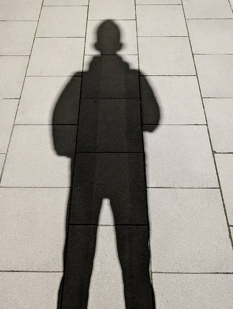 istock Long Human Shadow Silhouette On Bright Paved Sidewalk Cast By Low Sun Creating Minimal Urban People Background 2248853133