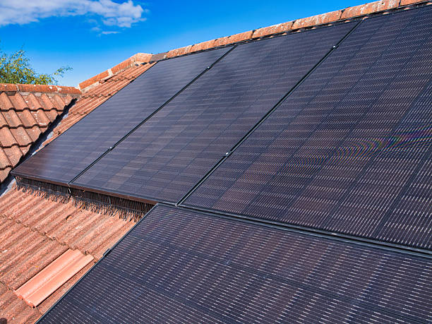 istock Rooftop Solar Panels on Tiled House Under Clear Blue Sky 2248853374