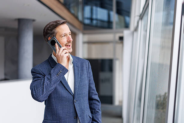 istock Businessman talking on mobile phone in modern office environment 2248853571