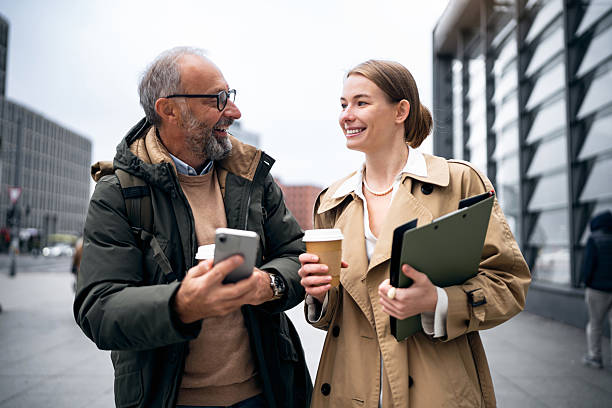 istock Business Colleagues Walking to Work in Berlin While Holding Coffees and a Tablet as One Shows Something on a Smartphone 2248856594