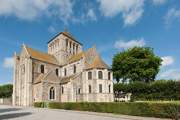 Lessay, France - August 26, 2016: The historic Lessay Abbey stands under a bright summer sky with scattered clouds on a sunny day.