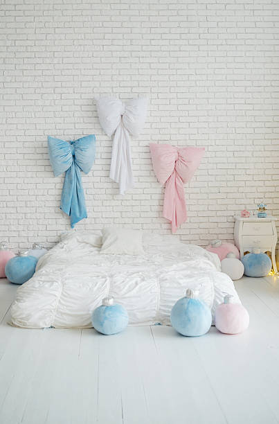 istock Soft plush bows and round ornaments decorate a white brick wall and cozy bed 2248861592