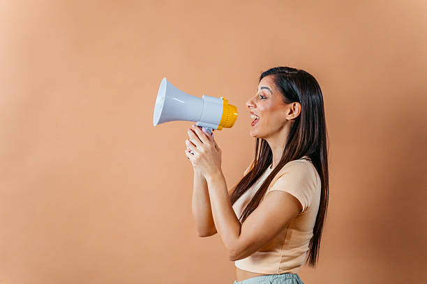 istock Young Woman Talking Into The Megaphone Against A Brown Background 2248861661