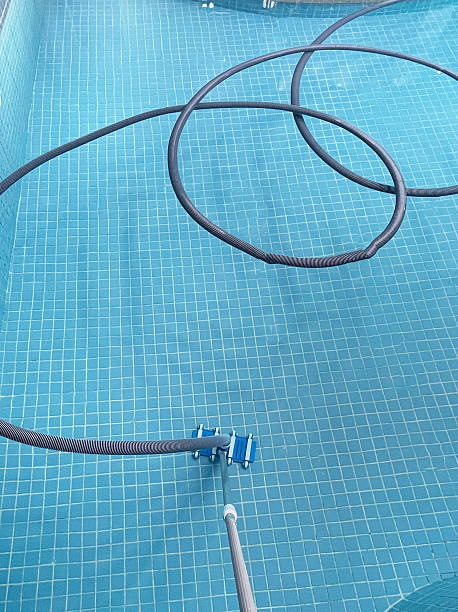 istock The image features a pool cleaning hose and vacuum head positioned inside a nearly empty swimming pool. The focus is on the essential tools used for maintaining cleanliness and preparing the pool for 2248861662