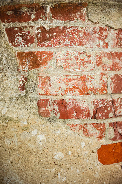 Aged brick wall with exposed layers and signs of deterioration
