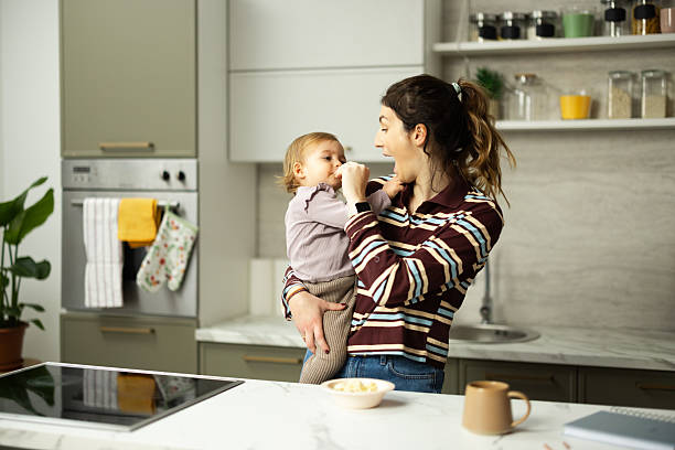 istock Mother feeding baby a healthy snack in kitchen 2248865965