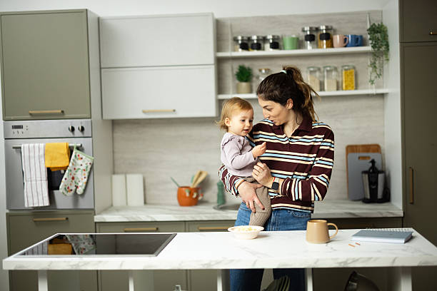 istock Mother holding toddler daughter talking in kitchen 2248865969