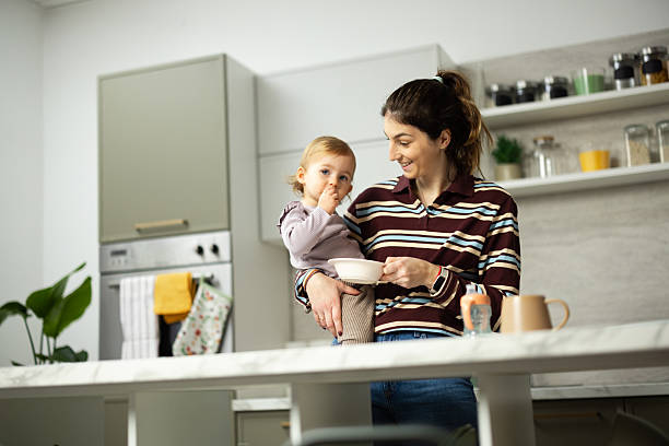 istock Mother holding baby eating in modern kitchen 2248865982