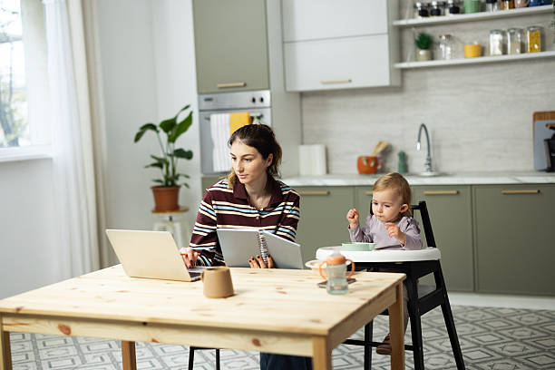 istock Mother working from home while baby eating in kitchen 2248866034