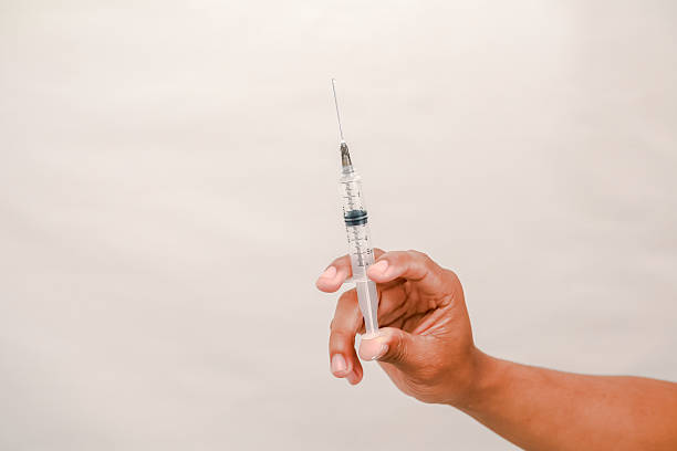 A hand holds a syringe containing medicine for vaccination or other medical treatment