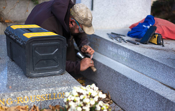 elderly unrecognizable religious woman cleaning a statue of a virgin in a cemetery.vertical image.
