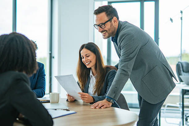 istock Business colleagues smiling discussing documents during office meeting 2248870560