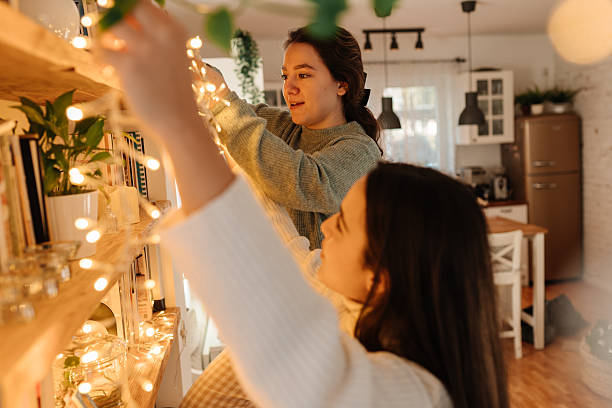 istock Friends decorating shelf with warm Christmas string lights 2248873658