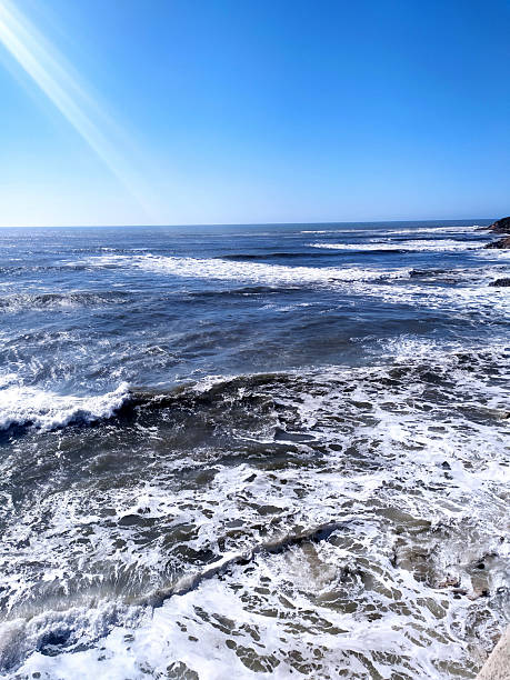 istock Serene seascape featuring foamy waves crashing on rocks beneath a clear blue sky, evoking peace and tranquility. Ideal for travel, nature, or coastal themes. 2248874306