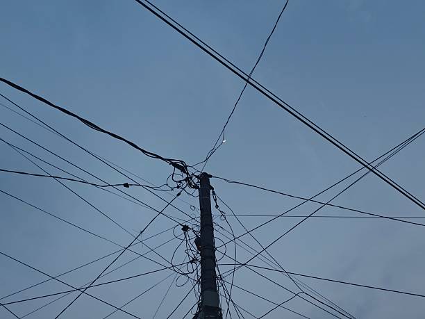 A tangled mess of cables on a small pole. There are so many tangled mess of cables