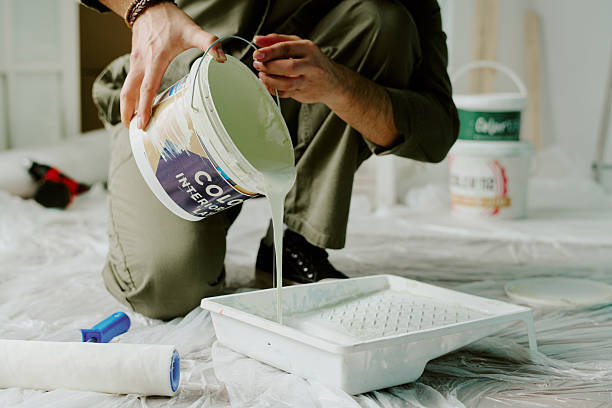 istock Man Pouring Paint into Tray While Renovating Apartment 2248881841