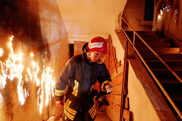 silouette of a firefighter against large fire in the dark, soft fokus