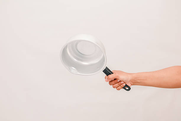 istock A hand holding an empty silver pot against a plain background ready to cook a meal 2248890183