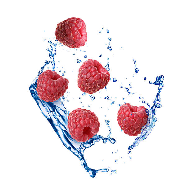 istock Fresh ripe raspberries and water splashes in air on white background 2248890795