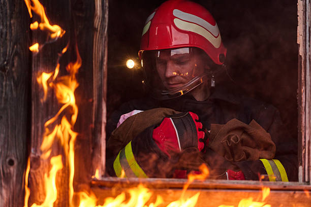 istock Firefighter rescuing a baby from burning building, fireman in action saving child, emergency situation, fire in house, danger, rescue operation, outdoor scene 2248892256