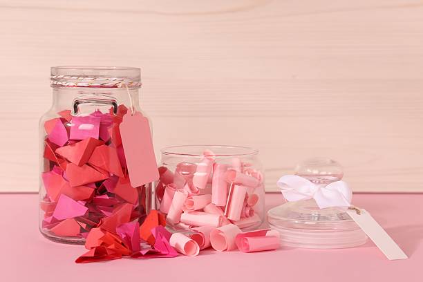 istock Color paper pieces in glass jars on pink table 2248892532
