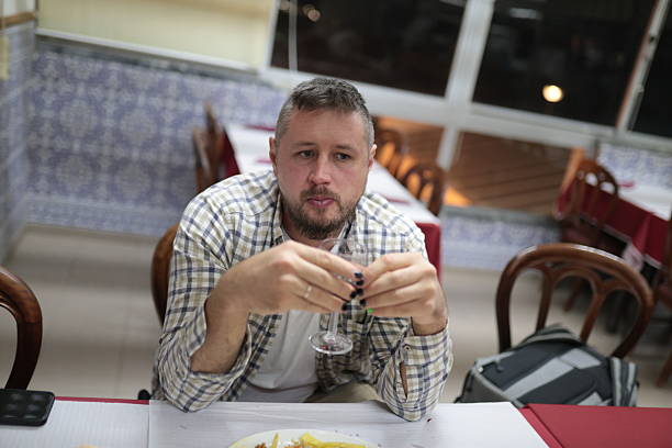 istock Man holding glass feeling thoughtful in restaurant or bar 2248892537