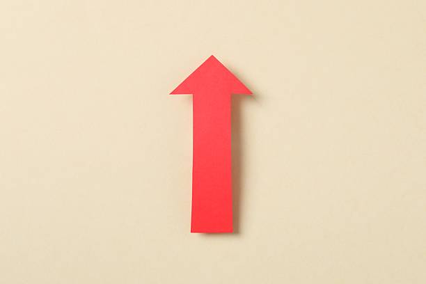 istock Red paper arrow on color background, top view 2248892918