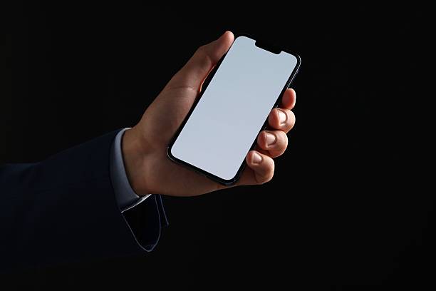 istock Man with modern smartphone on black background, closeup. Mockup for design 2248895731