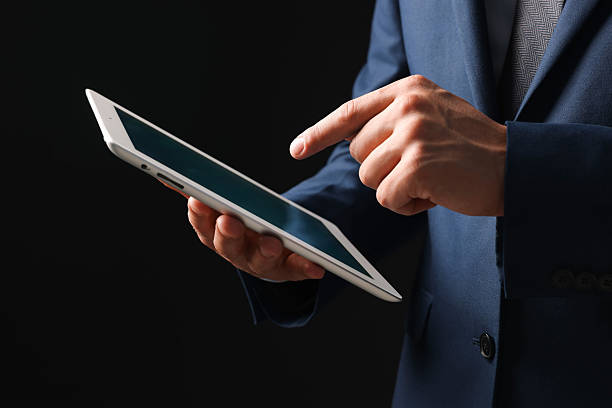 Man with modern tablet on black background, closeup