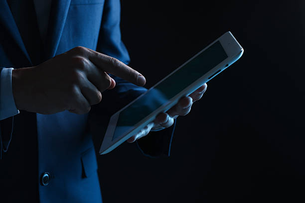 istock Man with modern tablet on black background, closeup 2248895738