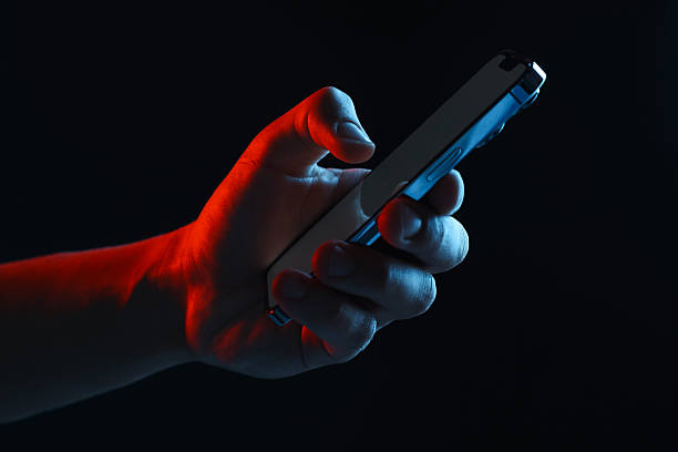 istock Man with modern smartphone on black background, closeup 2248895751