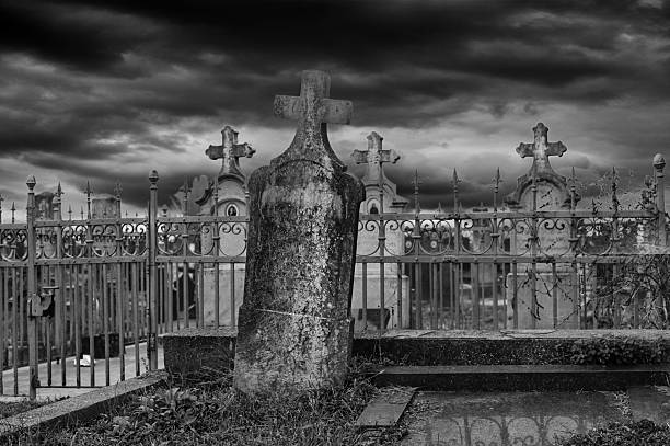 Old cemetery on the dark stormy autumn day in monochrome colors.
