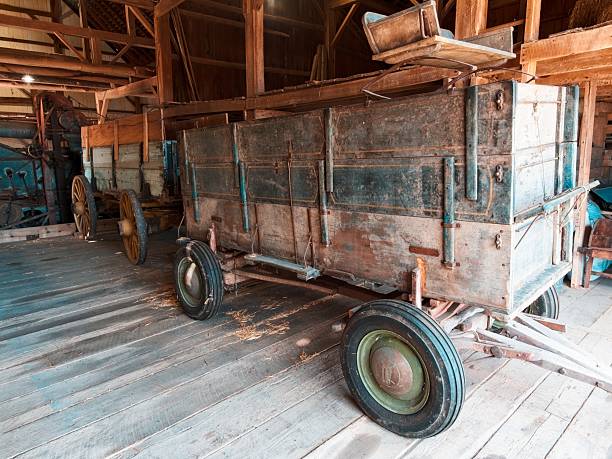 Vintage agricultural carts lined up in depression era barn.