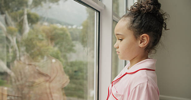 istock Sad, child and thinking at window in home with stress, abandoned and trauma from separation. Reflection, orphan or girl kid with depression in house with anxiety or waiting on adoption at foster care 2248902199