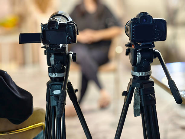 istock Cameras on tripods set up for a video interview in a studio setting 2248911461