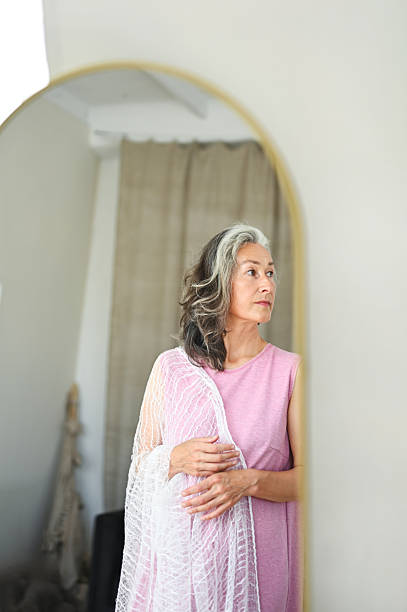istock Mature woman reflecting, looking away from mirror 2248916225