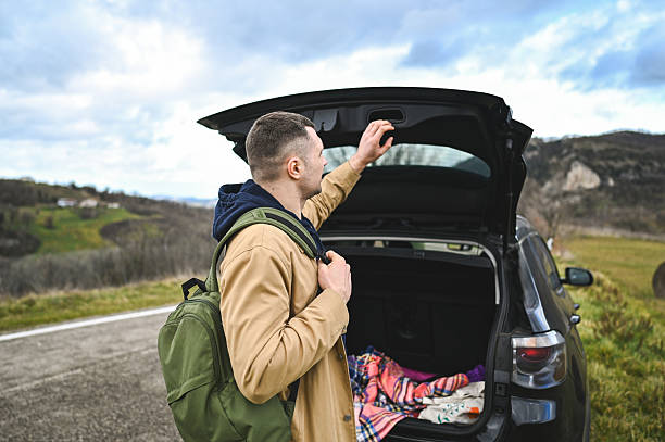 istock Young man closing car trunk during an autumn road trip 2248919151