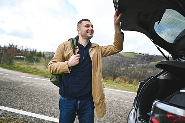 istock Man preparing car for countryside road trip 2248919157