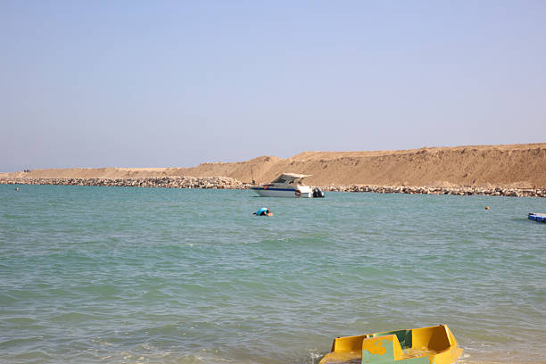 Dahab, Egypt - May 18, 2019: Two windsurfers ride across turquoise waves near coral reef in the Red Sea. High quality photo