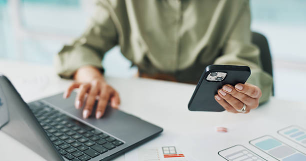 Phone, laptop and hands of worker with paperwork for mobile app software, website and ui design. Creative agency, startup and woman with tech, documents and layout for research, project and planning