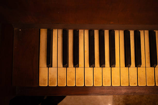 Close-up of piano keys showing worn ivory and black keys