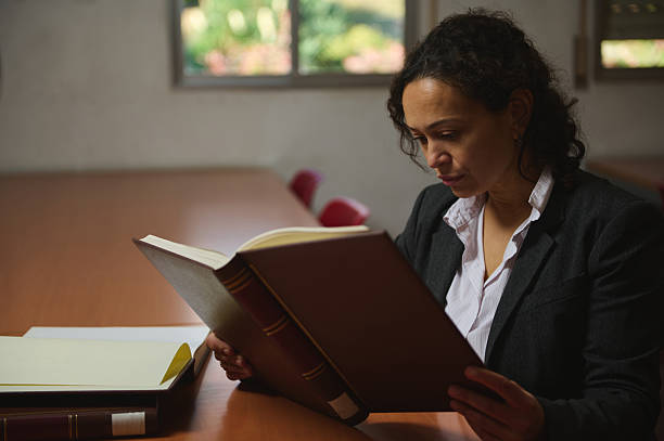 istock Professional Woman Reading a Large Book in a Quiet Office Study 2248924312