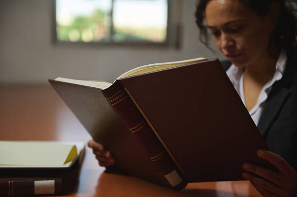 istock Woman Reading Large Leather Book At Desk With Additional Books In Quiet Study 2248924422
