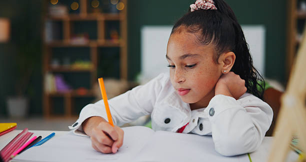 istock Home, writing and child with homework, learning and preparing for assignment, education or knowledge. Studying, kid and girl with notebook for project, growth and student with fine motor development 2248925350