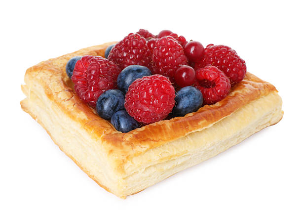 Colorful fruit pastries are arranged neatly, showcasing a variety of toppings like pineapple, kiwi, and cherries.